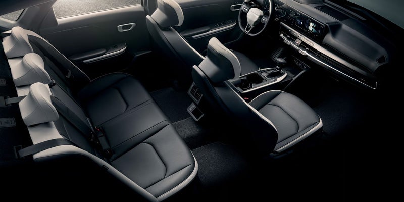 Spacious Kia K4 sedan interior viewed from above, featuring black seating for five passengers, a modern dashboard